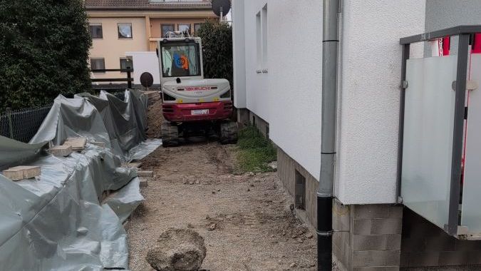 Präziser Aushub der Baugrube direkt am Haus mit unserem kompakten Mini-Bagger.