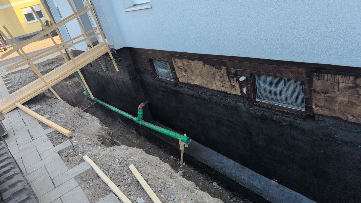 Ansicht der komplett abgedichteten Sockelzone vor der Anbringung von Styrodur und der Wiederverfüllung der Baugrube.