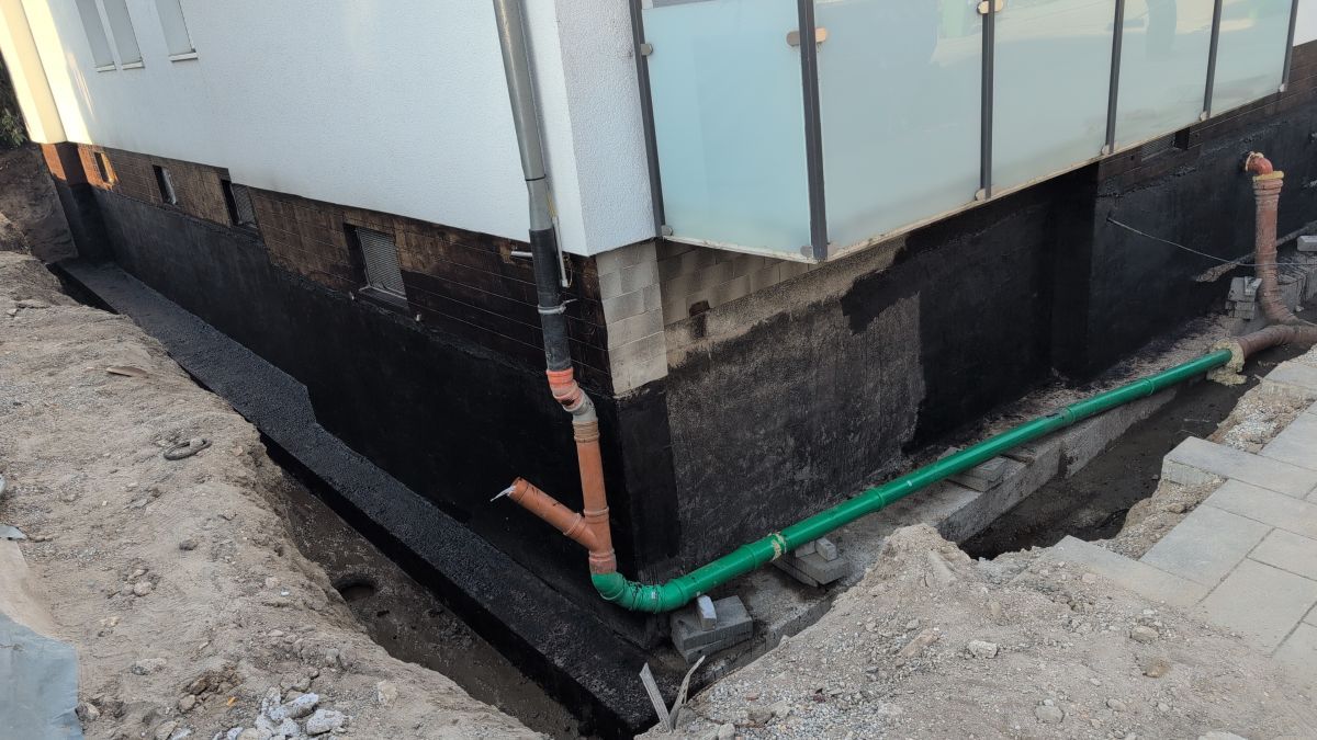 Die fertiggestellte, schwarze Bitumen-Dickbeschichtung mit neu verlegtem Rohrleitungssystem.