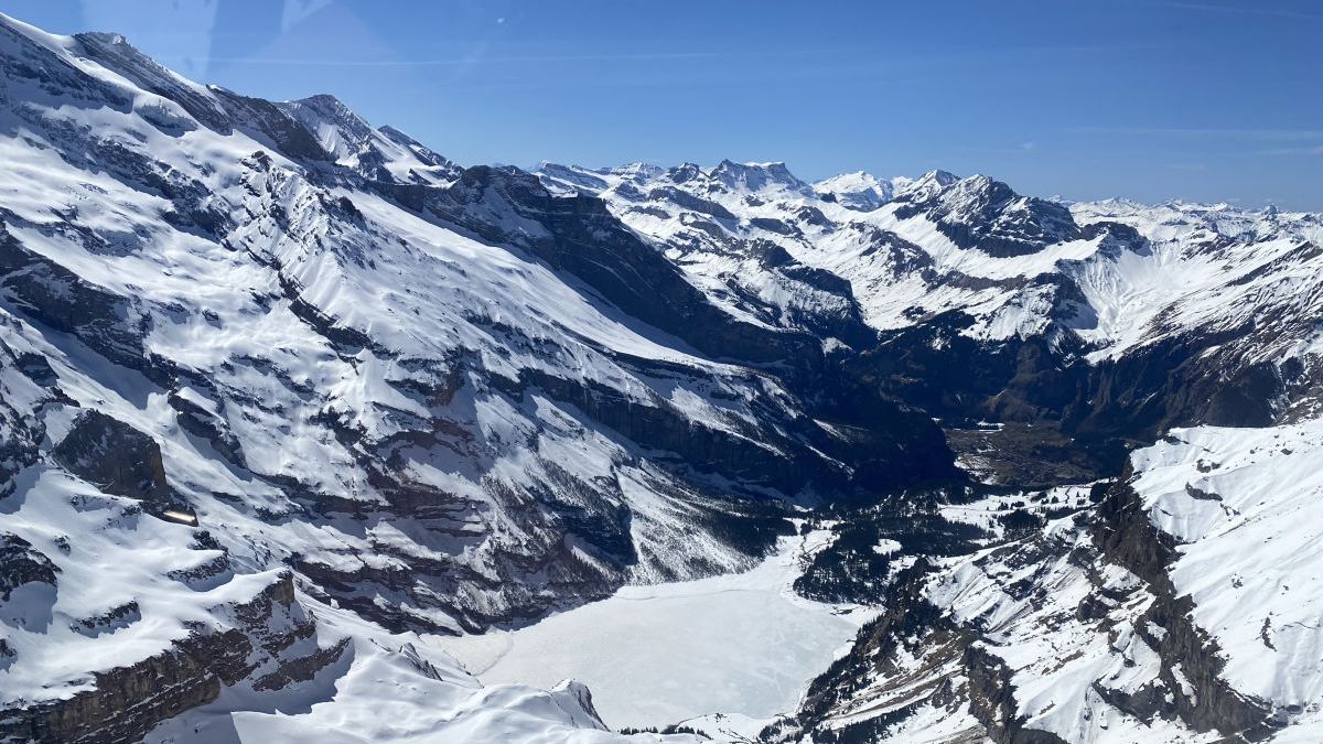 Auf diesen Helikopterflug sieht man Seen, Gletscher und weiss verschneite Berge.